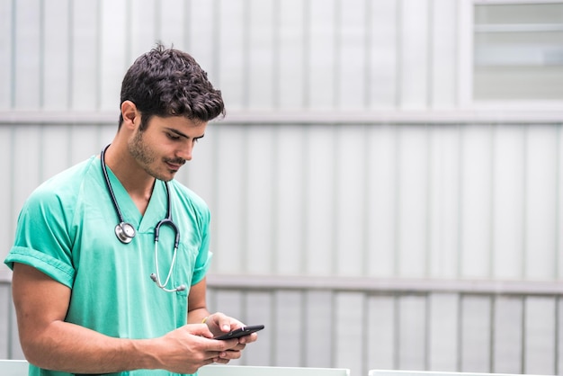 Male doctor using smartphone outdoors