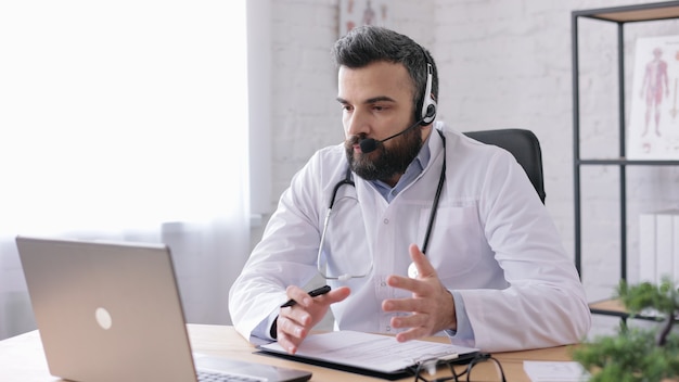 Male doctor wearing white coat has video call, video chat,conference with colleagues or patient.