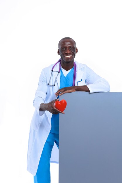 Male doctor with red heart and blank sign isolated on white background