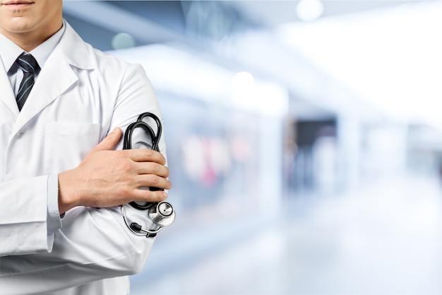 Male doctor with stethoscope on blurred hospital background