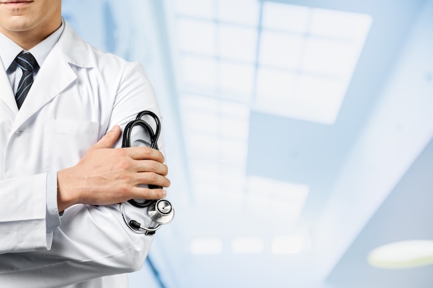 Male doctor with stethoscope on blurred hospital background