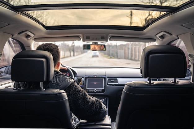 A male driver drives at speed through the streets of the city