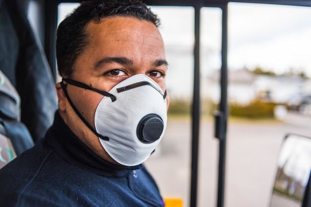 Male driver wearing protective medical mask for protection from virus disease driving intercity bus