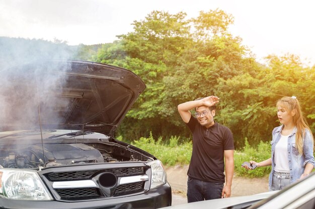 The male driver with girl friend was shocked to the point of losing his face after an accident with an engine that smokes with sun beam and outdoor background