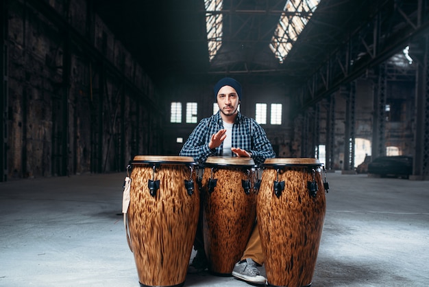 Male drummer plays on wooden drum