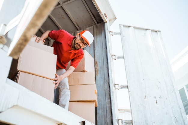 Male employee working unloading boxes from containers in a freight company