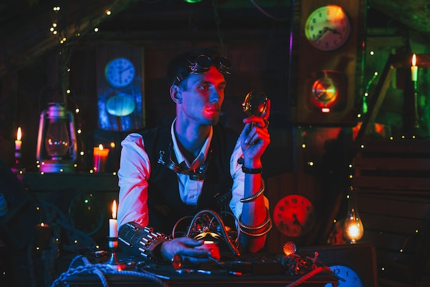 Male engineer inventor repairs a fantastic mechanism at a table in the workshop