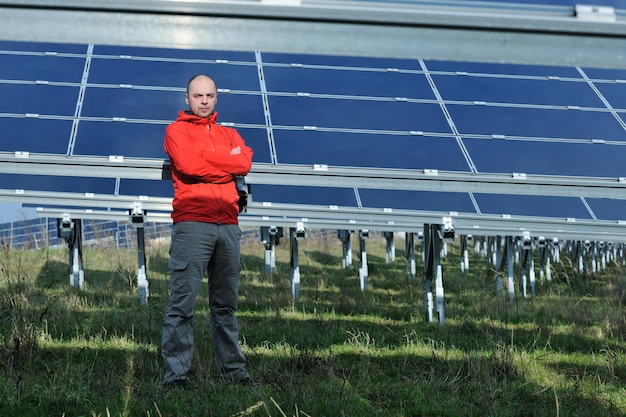 Male engineer at work place, solar panels plant industy in background