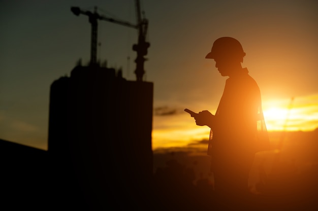 male engineer working construction site at Silhouette Sunset time