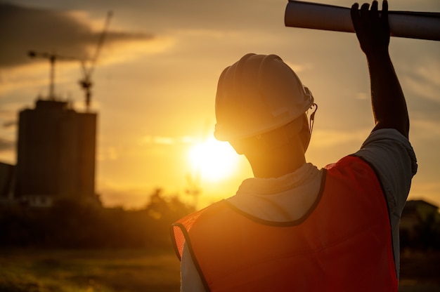 male engineer working construction site at Silhouette Sunset time