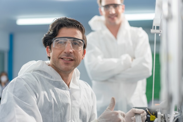 Male Engineers wear PPE checking and inspection machine in mask production line at factory