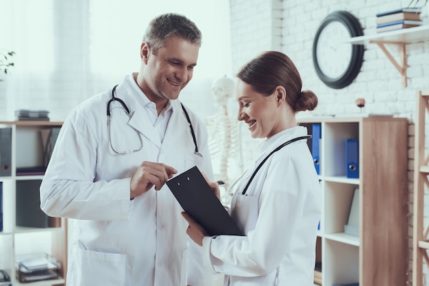 Male and female doctors with stethoscopes in office