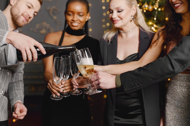 Male and female friends in elegant dresses celebrating New Year