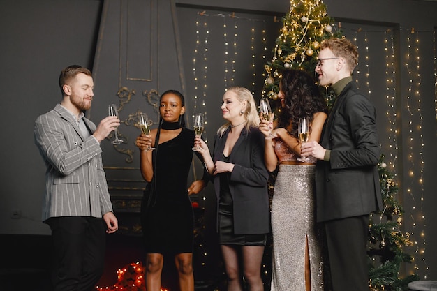 Male and female friends in elegant dresses celebrating New Year