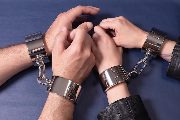 Male and female hands in iron handcuffs Sex toys Leisure