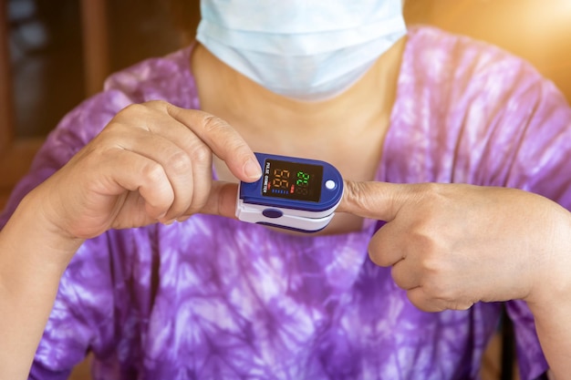 Male and Female hands using modern pulse oximeterUnrecognizable man using modern pulse oximetermale patient putting cliplike small device for blood oxygen saturation measuring and coronavirus