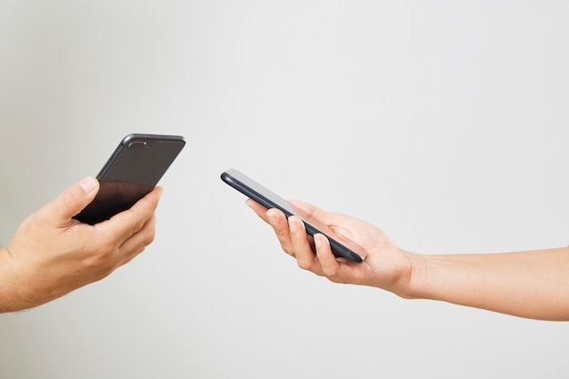 male and female hands with phones opposite each other