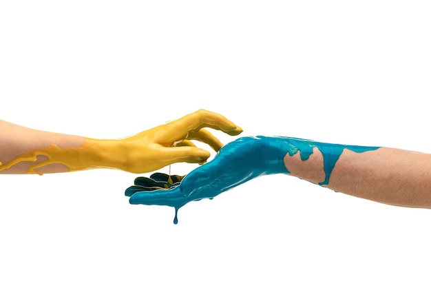 Male and female hands in yellow and blue paint touching each other isolated over white background