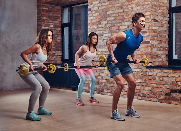 Male fitness coach shows how to do back workouts with barbell.