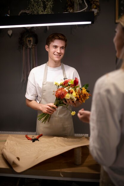 Photo male florist holding a beautiful bouquet