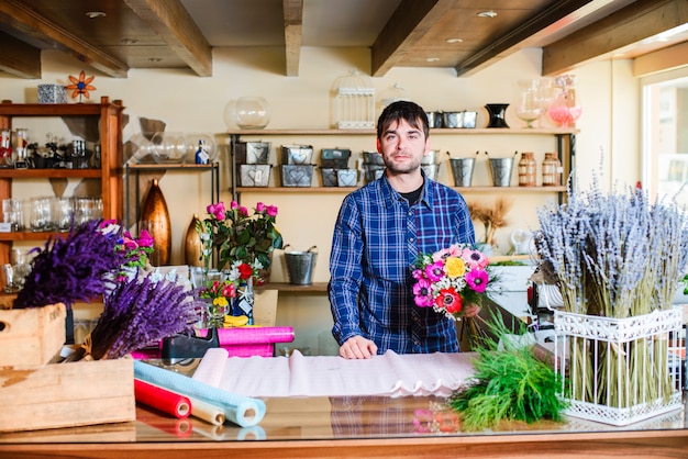 Male florist making bouquet in flower shop