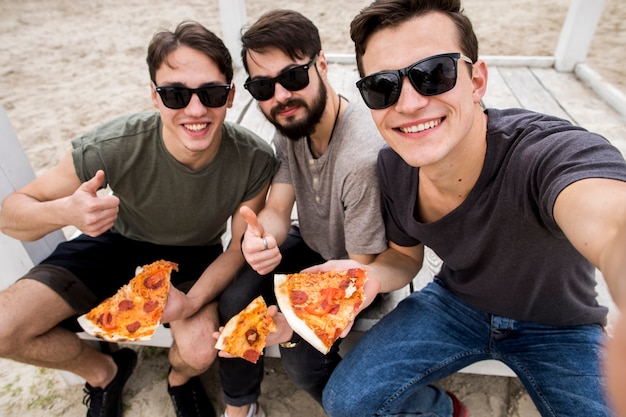 Photo male friends taking selfie with pizza