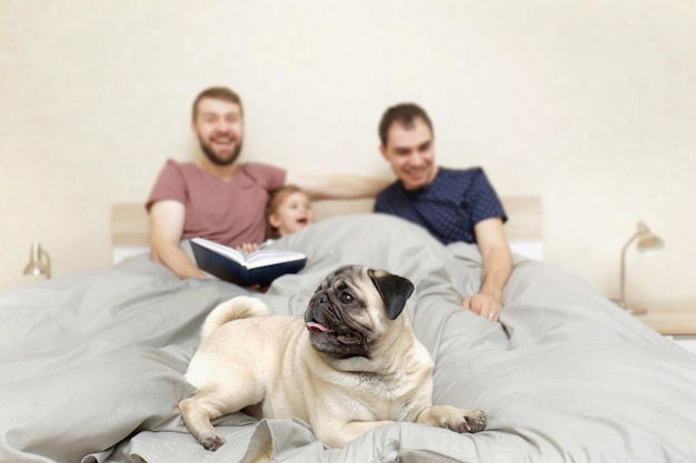 Male gay couple with children resting in bed at home