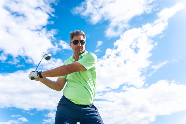 Male golf player on professional golf course hitting the ball with the stick driver