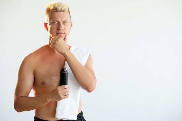 Male grooming Cosmetic product Morning routine Portrait of confident shirtless blond man holding shaving foam touching clean face isolated on light copy space advertising background