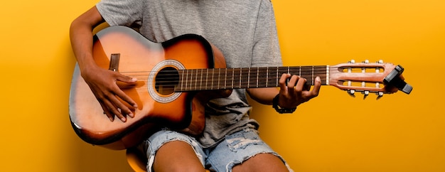 Male guitarist is tuning his guitar before playing guitar every time. music playing concept