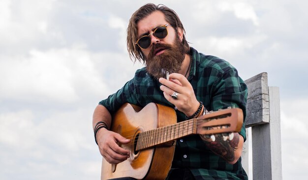 Male guitarist with musical instrument country music concept bearded man play acoustic guitar casual guy express human emotions hipster with long hair and moustache guitarist Move the beat