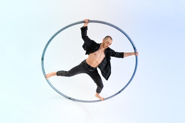 Male gymnast doing trick on cyr wheel