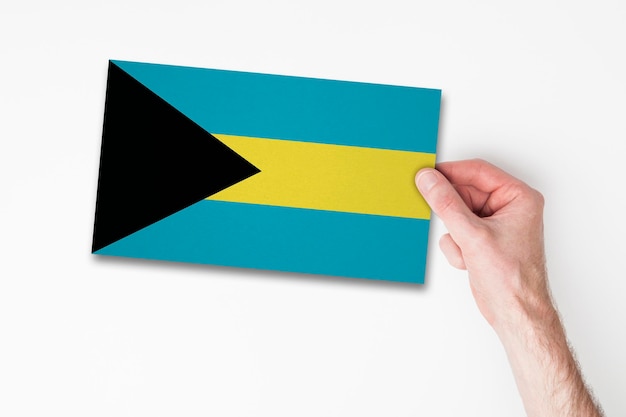 Male hand holding bahamas flag