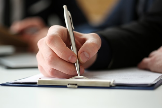 Male hand holding silver pen