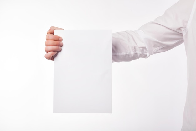 Male hand holding a square blank sheet of paper A4 ticket flyer invitation coupon etc isolated on white background