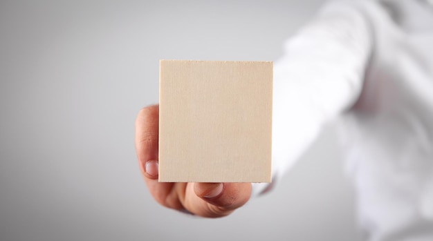 Male hand holding wooden empty board for your text