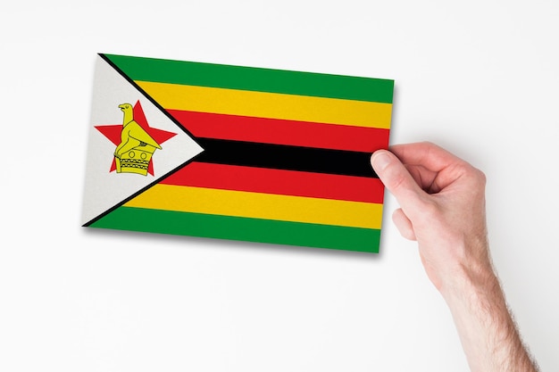 Male hand holding zimbabwe flag