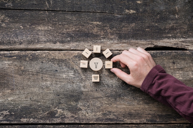 Male hand making a light bulb shape of wooden blocks in a conceptual image of innovation and idea.