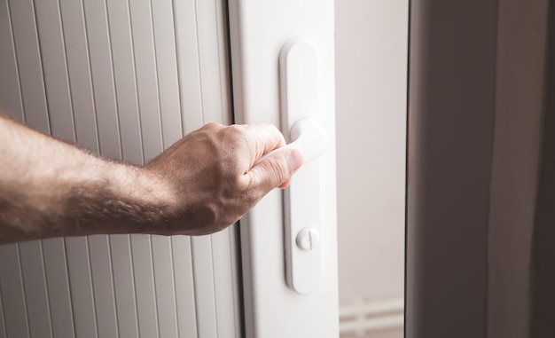 Male hand opening a door in home