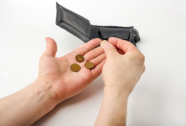 Male hand opening a wallet and count coins on white background. World economic crisis. Financial problem jobless, bankruptcy concept.