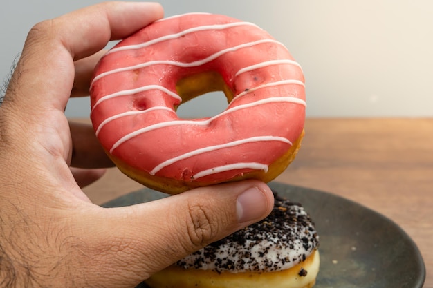 male hand picking up a delicious donut