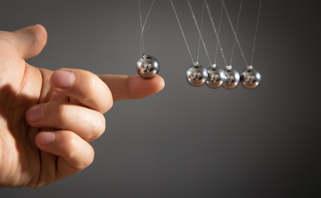 Male hand showing Newton's cradle balls