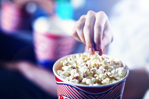 male hand taking popcorn from the box in the cinema