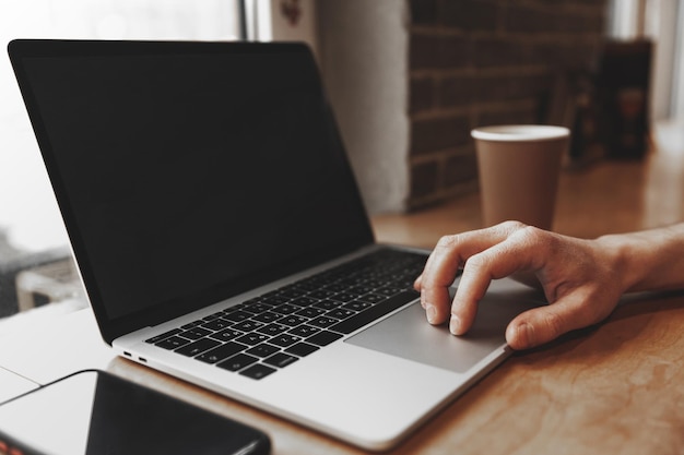 Male hand on the touchpad of a laptop with a black screen