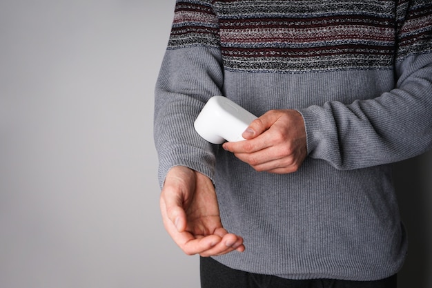 Photo male hand with modern fabric shaver and clothes on color background, place for text.