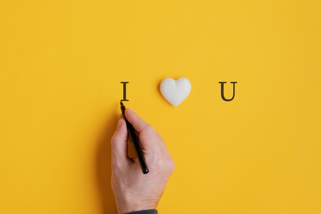 Male hand writing an I love you sign