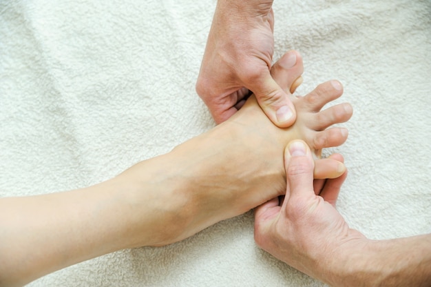 Male hands are massaging feet.