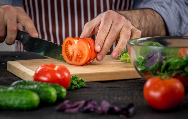 Photo male hands cutting vegetables for salad