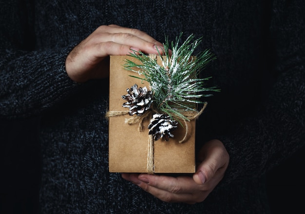 Male hands holding homemade christmas gift dark  Christmas 