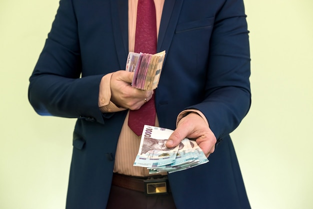 Male hands holding stack of ukrainian hryvnia banknotes isolated on green